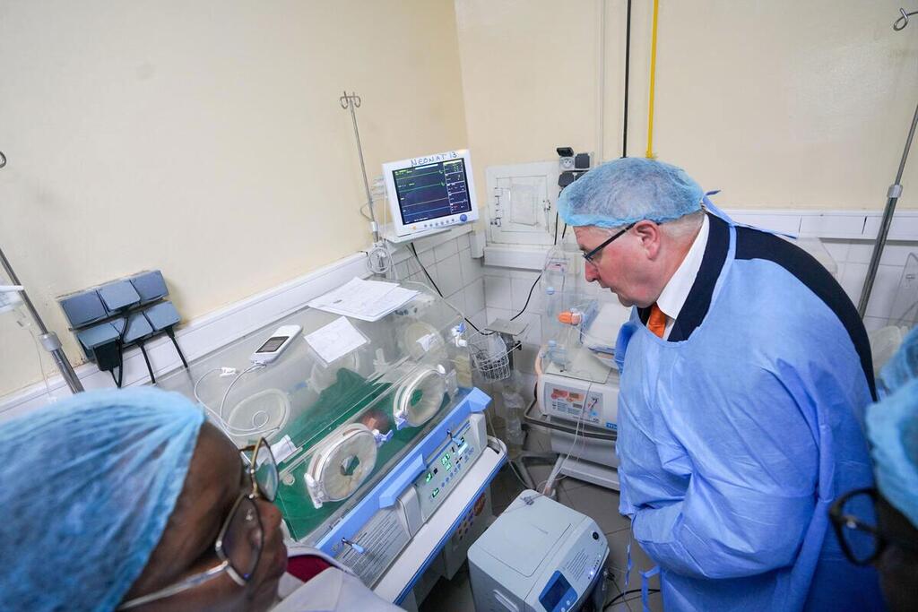 Le directeur exécutif adjoint de l'UNFPA, Andrew Saberton, en tenue médicale, observe un incubateur dans une maternité tchadienne.