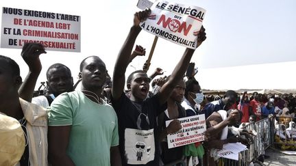 Des manifestants brandissent des pancartes lors d'une manifestation le 20 février 2022 sur la place de l'Obélisque à Dakar, réclamant un durcissement de la répression contre l'homosexualité.
