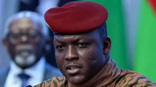 Le capitaine Ibrahim Traoré, vêtu d'une tenue militaire beige et d'un béret rouge, s'exprime lors d'une interview télévisée.